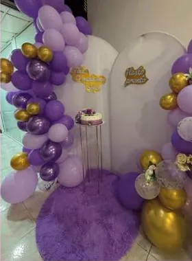Paneles blancos con guirnaldas de globos lilas y dorados